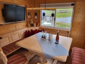 a dining room with a table and a tv in a tiny house at Allgäuer Mobilheim in Weiler-Simmerberg