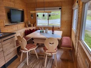 魏勒-锡默贝格Allgäuer Mobilheim的一间小房子里的饭厅,配有桌子和椅子