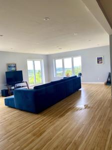 a living room with a blue couch and wooden floors at Eagles Perch in Margaree