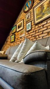 a brick wall with a couch and pictures on it at Hospedaria 71 in Campo Alegre +72 photos