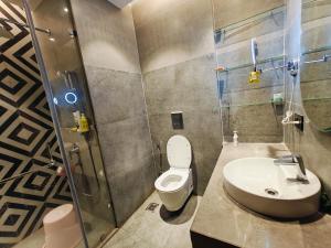 a bathroom with a shower and a toilet and a sink at Luxurious Suite with Panoramic glass wall in Ghaziabad