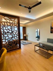 a living room with a couch and a ceiling fan at Luxurious Suite with Panoramic glass wall in Ghaziabad +3 photos