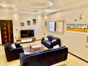 a living room with two blue couches and a tv at wawat in Abu Simbel