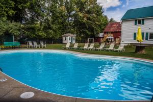 uma piscina com cadeiras e uma casa em Cranmore Inn and Suites, a North Conway boutique hotel em North Conway