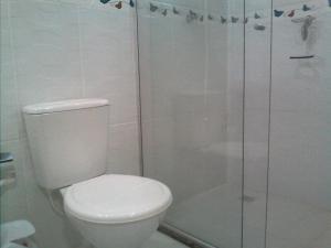 a white bathroom with a toilet and a shower at Estudio dos Bonecos in Canela +9 photos