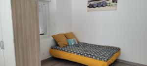a small bed in a room next to a window at Les orangers in Ravilloles