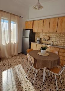 a kitchen with a table with chairs and a refrigerator at Michael's Home Cycladic Cottage House in Kini