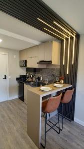 una cucina con isola con due sedie da bar di Yoo 914 - Luxury Loft a Porto Alegre