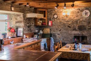 a kitchen with a stone wall and a counter top at Angelas Farmhouse Lauragh by Trident Holiday Homes in Lauragh