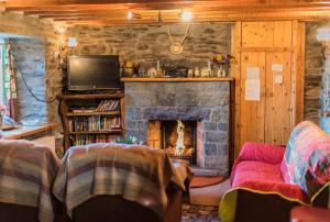 a living room with a fireplace and a tv at Angelas Farmhouse Lauragh by Trident Holiday Homes in Lauragh