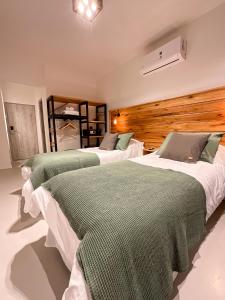 a bedroom with two beds with green blankets at Parry Smart Hotel in Puerto Madryn +23 photos
