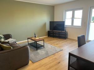 a living room with a couch and a flat screen tv at Exklusive und moderne Ferienwohnung in Thiendorf