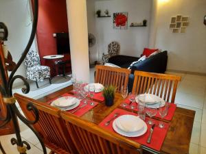a table with plates and wine glasses on it at Ecrin de douceur chic en ville in Lomé