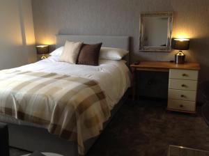 a bedroom with a bed and a dresser at Rooms @ Number Six in Oakham