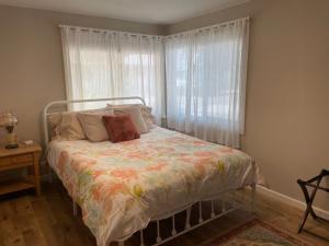 a bedroom with a bed and a window with curtains at Riverbed House in Middletown