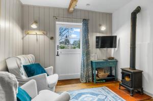 a living room with a wood stove and a door at Welsh Cottage in Little Marcle