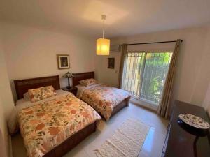 a bedroom with two beds and a window at Madinaty Gardens in Madinaty +46 photos