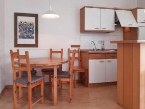 a kitchen with a wooden table and chairs and a sink at Ferienwohnungen Blaues Haus, Putbus in Putbus +28 photos