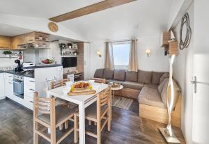 a kitchen and living room with a table and a couch at Nature & Sérénité in Litteau