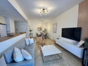 a living room with a couch and a tv at Puerto De La Duquesa in Manilva