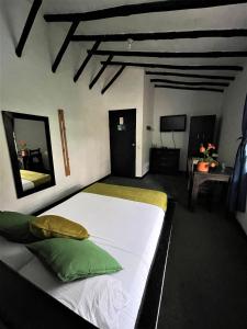 a bedroom with a large white bed with green pillows at Hotel Premium Real in Medellín +26 photos