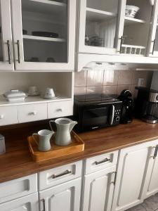 a kitchen with white cabinets and a microwave at Ingrid Residence in Ocna-Mureşului