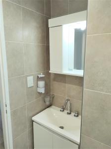 a bathroom with a sink and a mirror at Paraíso Home in El Calafate