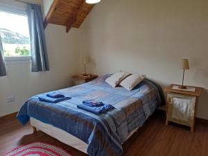 a bedroom with a bed with two blue towels on it at La casa de Gaby in San Martín de los Andes