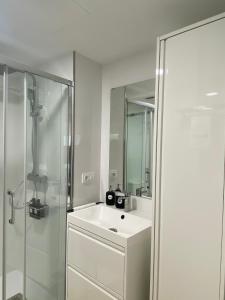 a white bathroom with a sink and a shower at Alojamientos Ría de Vigo & Alborada in Moaña