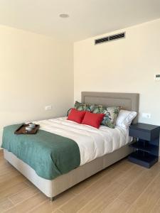 a bedroom with a large bed with red pillows at Alojamientos Ría de Vigo & Alborada in Moaña