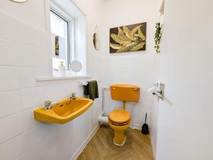 a bathroom with a yellow sink and a toilet at Central Home in Portsmouth Sleeps 10 in Portsmouth
