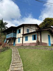 een huis met blauwe ramen en een stenen pad bij Villa Serenità - Casa Vecchia in Santa Teresa