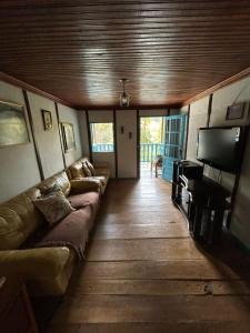 een woonkamer met een bank en een flatscreen-tv bij Villa Serenità - Casa Vecchia in Santa Teresa