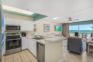 a kitchen with white cabinets and a view of the ocean at Pelican Isle 206 in Fort Walton Beach