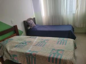 a bedroom with two beds and a blanket on the bed at Recanto das Flores in Extrema