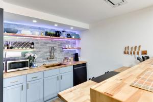 a kitchen with white cabinets and a brick wall at Modern Chic Retreat Luxe Comfort and Style in Omaha