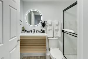 a bathroom with a toilet and a sink and a mirror at Modern Chic Retreat Luxe Comfort and Style in Omaha +58 photos