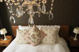 una camera da letto con letto, cuscini e lampadario a braccio di ieperlee 23 Holiday Home a Ypres