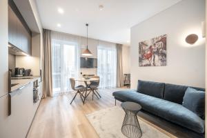 una sala de estar con un sofá y una mesa en Brand New Downtown Apartments by Reside Baltic, en Vilna