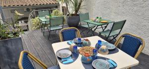 una mesa blanca con sillas y jarrones en el patio en Chambres d'hôtes Le Clos Bleu, en La Rochelle
