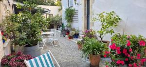 un jardín con macetas, mesa y sillas en Chambres d'hôtes Le Clos Bleu, en La Rochelle
