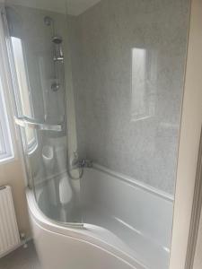 a shower with a glass door in a bathroom at Golden Sands Coop 103 in Kinmel Bay +26 photos