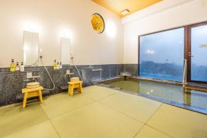 una piscina con dos taburetes y un reloj en la pared en Hidamari Ichinoyu, en Hakone