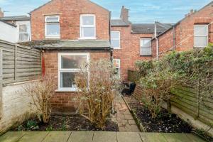 ein altes Backsteinhaus mit Büschen davor in der Unterkunft Comfy, stylish 3 bed townhouse in Northampton