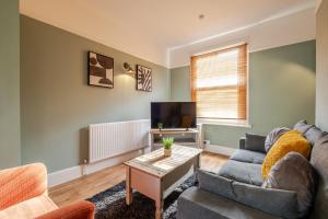 ein Wohnzimmer mit Sofa und Fernseher in der Unterkunft Comfy, stylish 3 bed townhouse in Northampton
