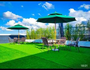 a patio with a table and chairs and umbrellas at Eika - Refined and luxurious studio Apartment in Nairobi