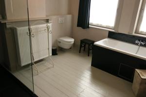 uma casa de banho com uma banheira, um WC e um lavatório. em ieperlee 23 Holiday Home em Ypres