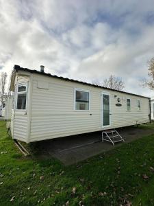 a white trailer is parked in a yard at Island staycations holiday home in Eastchurch