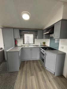 a small kitchen with white cabinets and a sink at Island staycations holiday home in Eastchurch