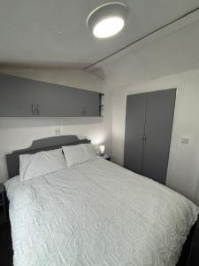 a bedroom with a large bed with a white comforter at Island staycations holiday home in Eastchurch